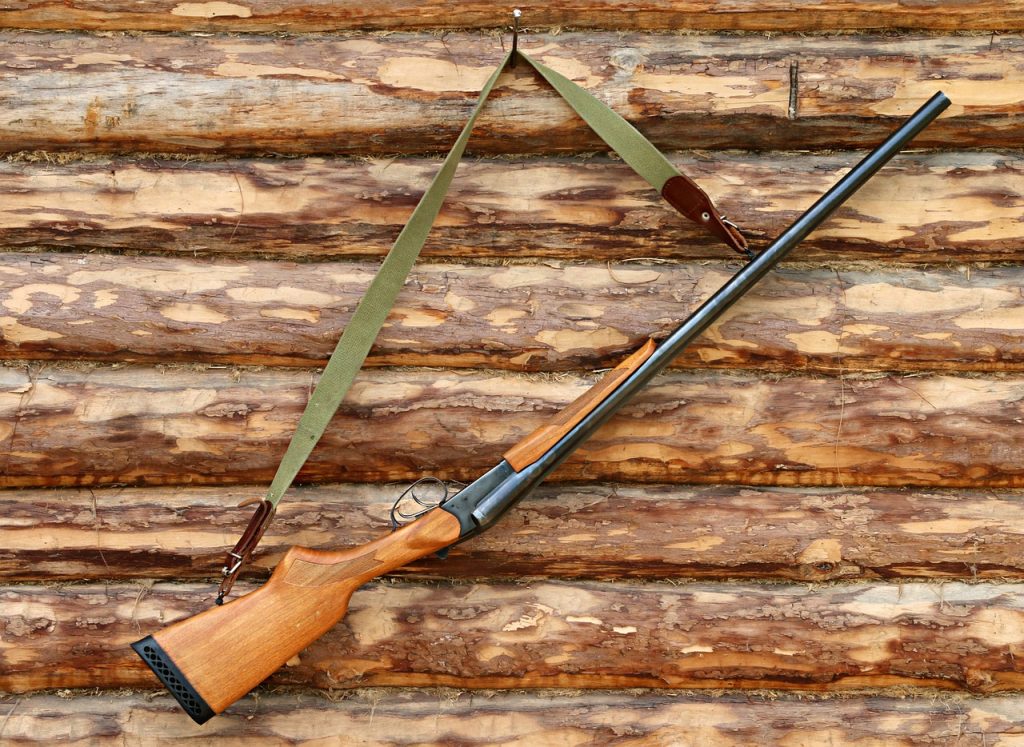 Picture of a shotgun hanging on a log wall