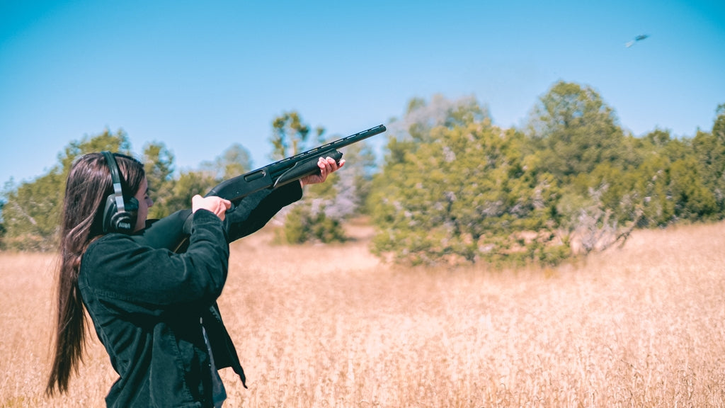Picture of a woman shooting skeet with a shotgun
